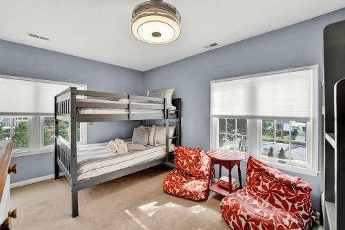 a bedroom with two bunk beds and a chair at Gorgeous historic Victorian with 8 bedroom/4 baths in Wildwood