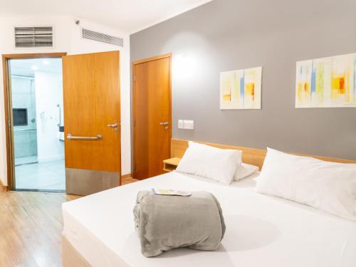 a bedroom with a white bed and a bathroom at Hotel Mega Polo in Sao Paulo