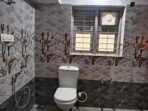 łazienka z toaletą i oknem w obiekcie Mary's homestay w mieście Kalpatta
