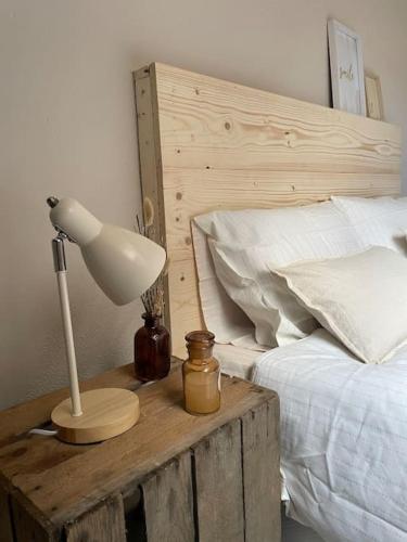 une lampe sur une table en bois à côté d'un lit dans l'établissement L'appart Saint-Laurent, à Chalon-sur-Saône