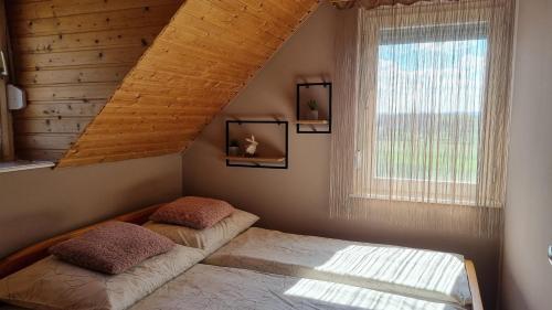 - une chambre avec 2 lits et une fenêtre dans l'établissement HutiAgi apartman, à Siófok