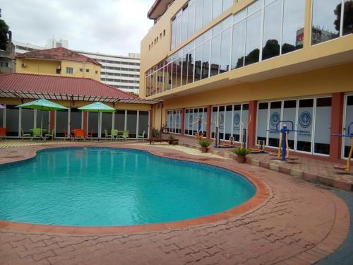 a large swimming pool in front of a building at Pensao Martins in Maputo