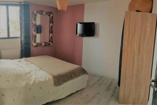 1 dormitorio con cama y espejo en la pared en Pied à terre central Pays Basque, en Larressore