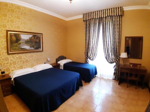 una camera d'albergo con due letti e una finestra di Hotel Mariano a Roma