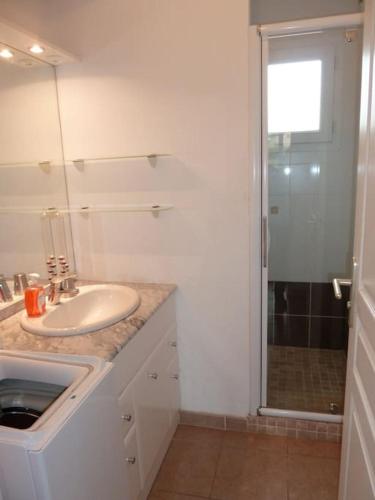 Un baño blanco con lavabo y ducha. en T3 en rdj pour 6 pers dans résidence avec piscine, en Propriano