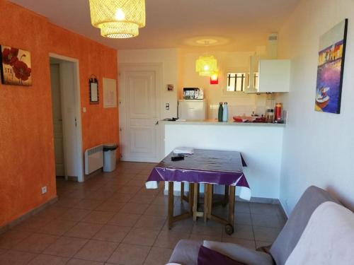 Una sala de estar con una mesa y una cocina. en T3 en rdj pour 6 pers dans résidence avec piscine, en Propriano