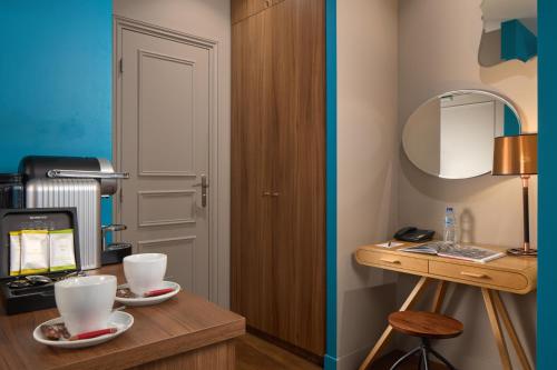 a room with a desk with two cups on it at Le Robinet d'Or Paris Canal Saint Martin in Paris