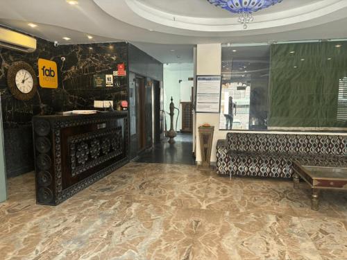 a room with a couch and a clock on the wall at Tipsyy Inn & Suites Jaipur in Jaipur