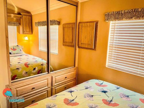 a bedroom with a bed and a large mirror at Pinecraft Cottage Tiny Home in Sarasota