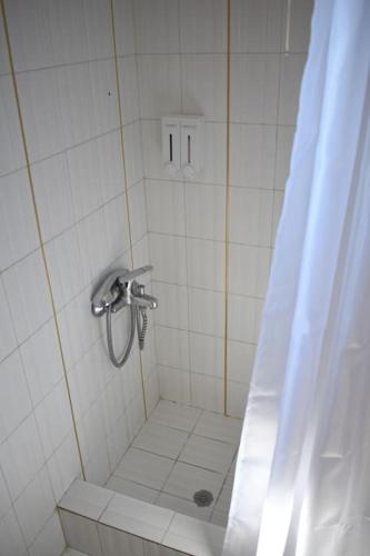 a bathroom with a shower with a shower curtain at Μαγευτική Περδικιώτικη Μεζονέτα in Perdika