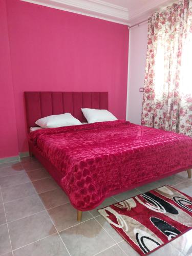 1 dormitorio con 1 cama con pared de color rosa en Dar Zaineb, en Túnez