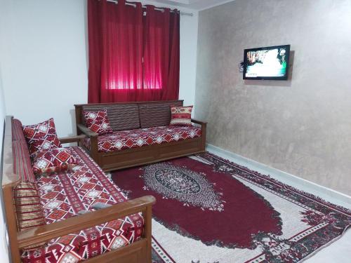 sala de estar con sofá y TV en Dar Zaineb, en Túnez