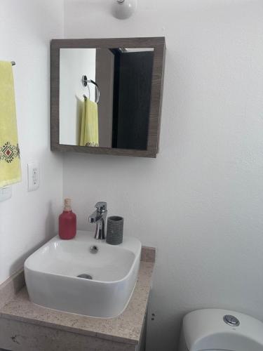 a bathroom with a sink and a mirror and a toilet at Casa Acapulco de mis amores Diamante in Acapulco