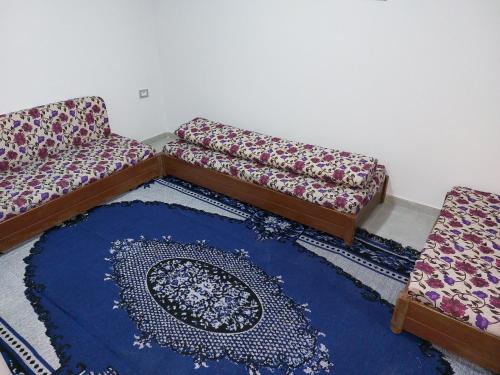 una sala de estar con 2 sofás y una alfombra azul en Dar Zaineb, en Túnez