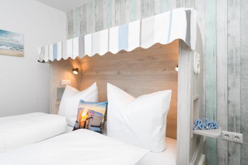 a bedroom with two beds with white pillows at Haus Strandkorb mit Frühstücksoption in Bensersiel
