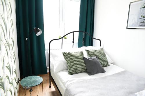 sypialnia z łóżkiem z zielonymi i białymi poduszkami w obiekcie Apartament 55 w Węgierskiej Górce