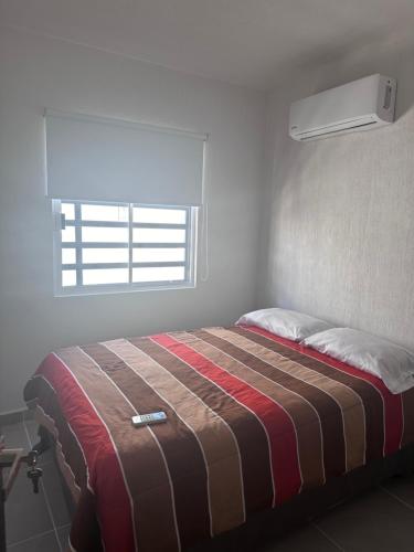 Posto letto in una camera bianca con finestra di Casa Acapulco-Barra Vieja a Icacos