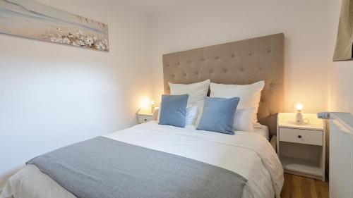 1 dormitorio con 1 cama grande con almohadas azules en FeWo Catalina, en Westerstede