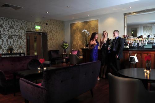 a man and a woman standing in a living room at The Royal Hotel Cardiff in Cardiff