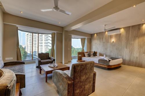 een hotelkamer met een bed en een bank en stoelen bij Artilla Inn in Ahmedabad