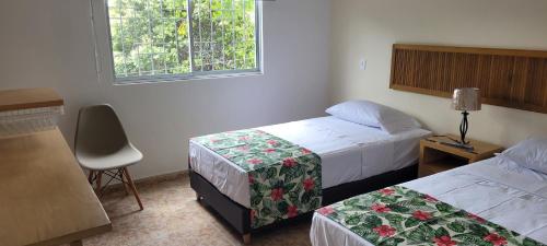 Habitación de hotel con 2 camas y ventana en Casa 59 - Guest House, en Bucaramanga