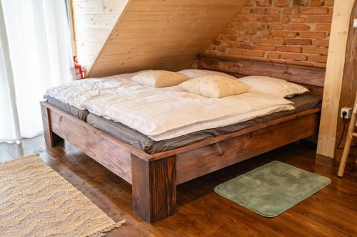 a wooden bed with pillows on it in a room at Apartmaji Babi in Markovci