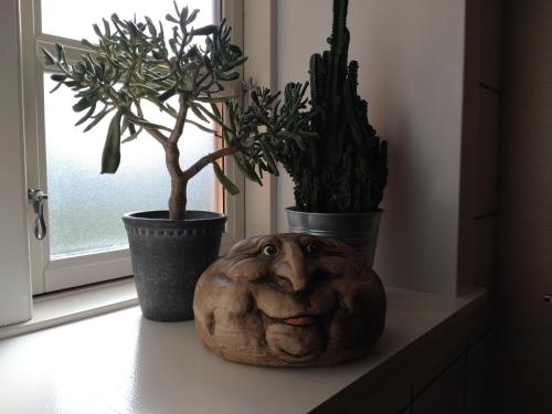 a statue of a face sitting on a window sill with plants at Akaciegaarden Bed & Breakfast in Hårlev