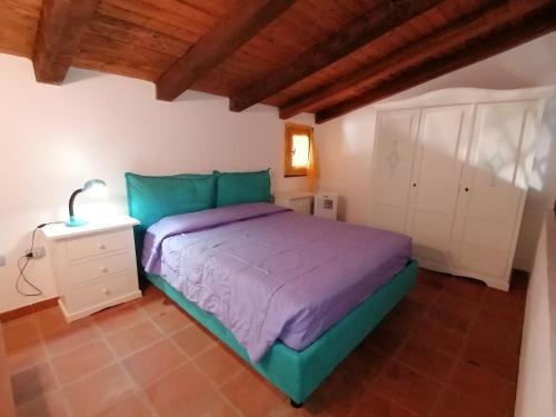 a bedroom with a green bed and a white cabinet at Appartamento centralissimo in San Teodoro in San Teodoro