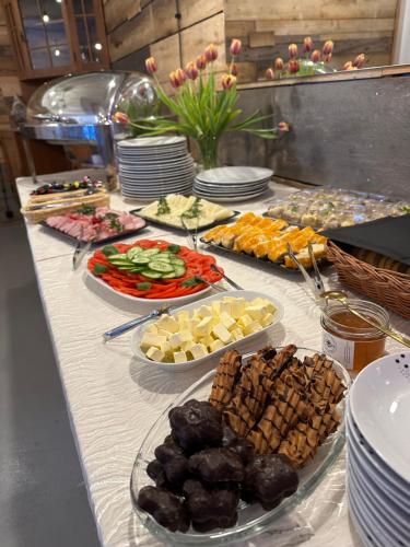 a buffet with many plates of food on a table at Hotel Krasnoludki in Sosnówka