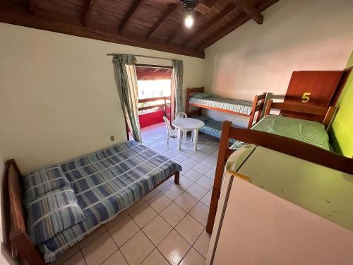 ガロパバにあるPousada Via Ferrugemのベッドルーム1室(二段ベッド2組、テーブル付)
