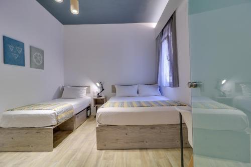 two beds in a room with a window at athensotel in Athens
