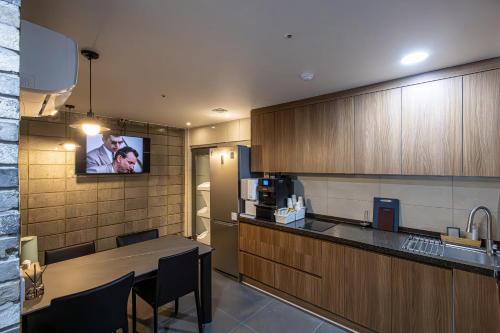 a kitchen with a tv hanging on the wall at K Stay 3rd Myeongdong City in Seoul