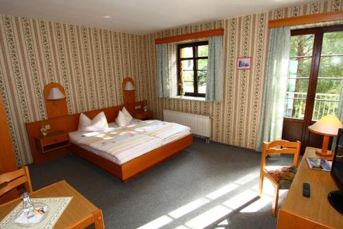 Schlafzimmer mit einem Bett, einem Tisch und Stühlen in der Unterkunft Hotel Wenzels Hof in Zwethau