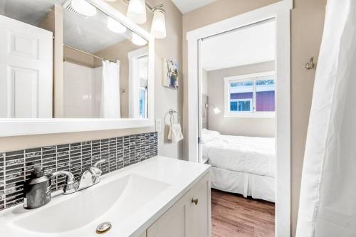 a white bathroom with a sink and a mirror at Secluded Cabin On The Lake #7 in West Kelowna
