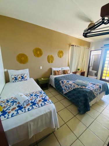 een slaapkamer met 2 bedden met blauwe en witte lakens bij Pousada Solar da Praia Maragogi in Maragogi