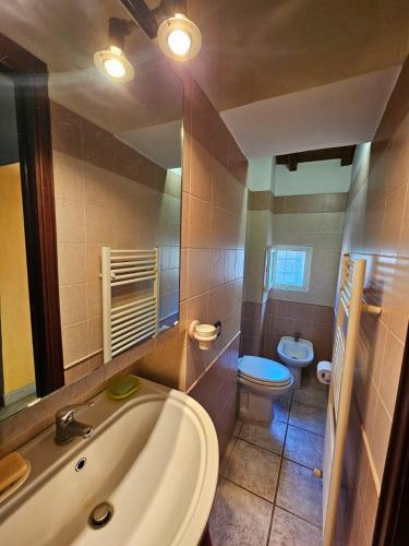 een badkamer met een bad, een toilet en een wastafel bij La Loggetta in Valentano