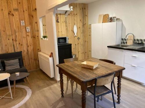 une cuisine et une salle à manger avec une table dans une pièce dans l'établissement Appartement Cosy tout confort au cœur de ville., à Sète