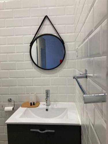 une salle de bain avec un lavabo et un miroir au mur dans l'établissement Appartement Cosy tout confort au cœur de ville., à Sète