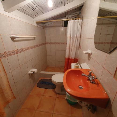 ein Badezimmer mit einem roten Waschbecken und einem WC in der Unterkunft El Colibrí Azul in Quito