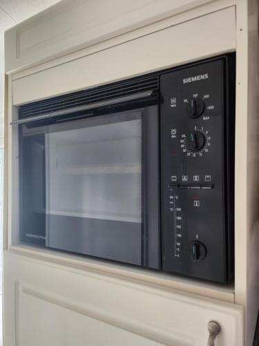 a microwave oven sitting inside of a cabinet at Chalet Relax in Putten