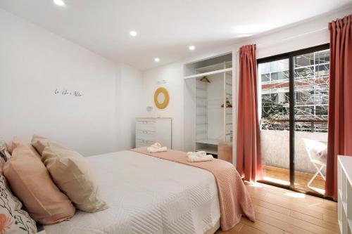 ein Schlafzimmer mit einem weißen Bett und einem großen Fenster in der Unterkunft El Rinconcito de Villalba Hervás in Santa Cruz de Tenerife