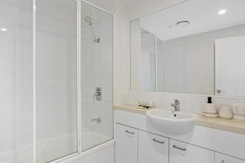La salle de bains blanche est pourvue d'un lavabo et d'une douche. dans l'établissement Coastal 3-Bed with Parking, Pool & Ocean View, à Scarborough
