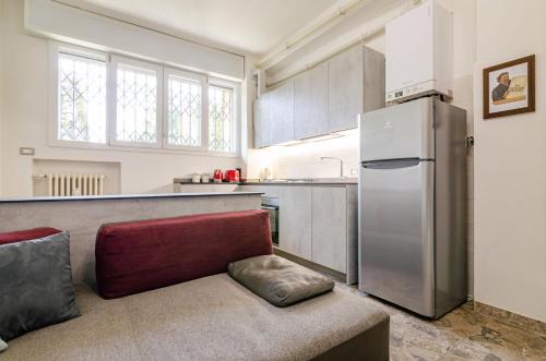 a kitchen with a couch and a refrigerator at B&B Corsini in Bologna
