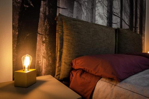 a bedroom with a bed with a lamp on a table at B&B Corsini in Bologna