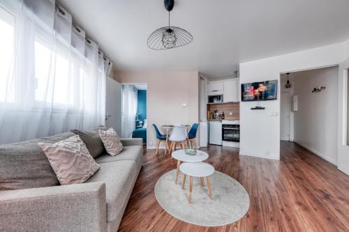 un salon avec un canapé et une table dans l'établissement Appartement cosy et calme, à Élancourt