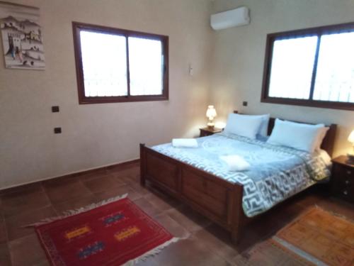 een slaapkamer met een bed en 2 ramen bij Family villa with swimming pool and a wonderful mountain view in Marrakesh