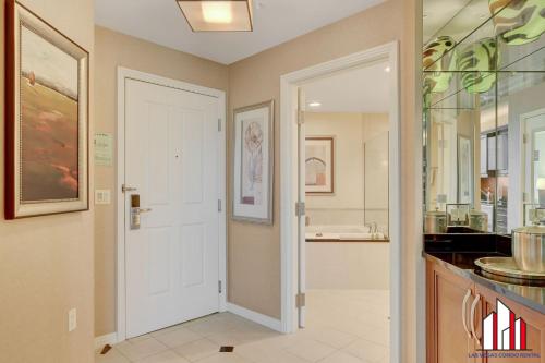 a kitchen with a white door and a sink at MGM Signature-28-719 Strip View Jacuzzi Studio in Las Vegas