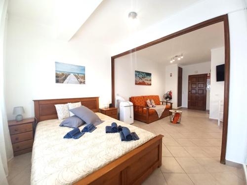 um quarto com uma cama grande e toalhas azuis em Pink Beach Apartment 223 em Portimão