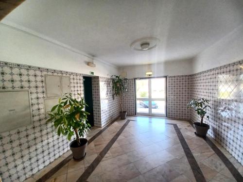 um quarto com vasos de plantas nas paredes em Pink Beach Apartment 223 em Portimão