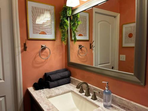 een badkamer met een wastafel en een spiegel bij Augi's Den. Close to Masters. Modern. Fun in Augusta